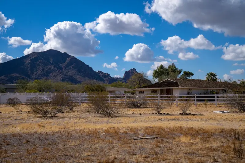 A farmhouse in the Arizona desert with mountains behind