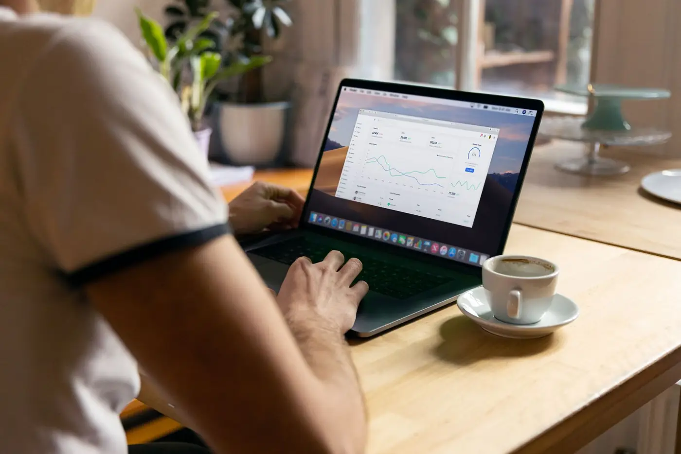 A laptop showing analytics charts next to a cup of coffee