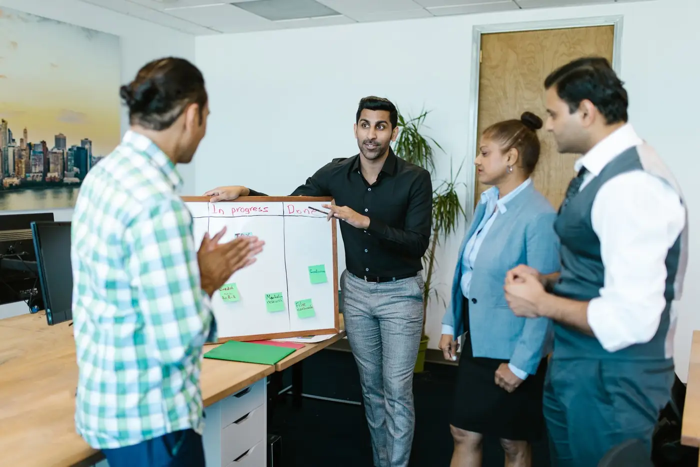 A team planning a project around a whiteboard in a bright office